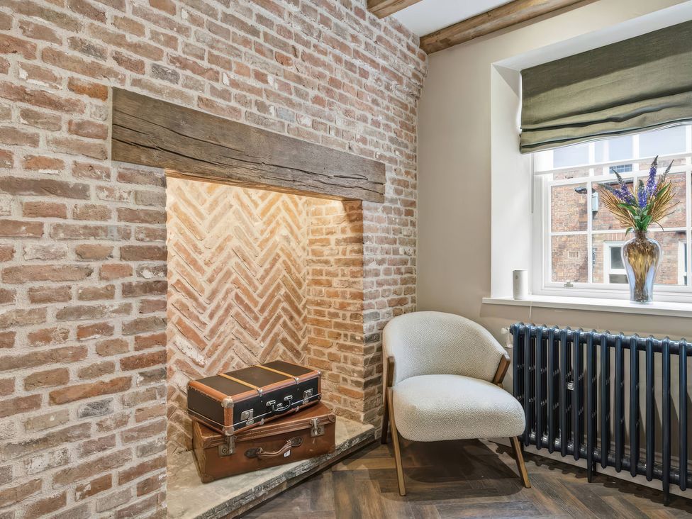 A living room with a brick wall and a suitcase at Apt.1 in 