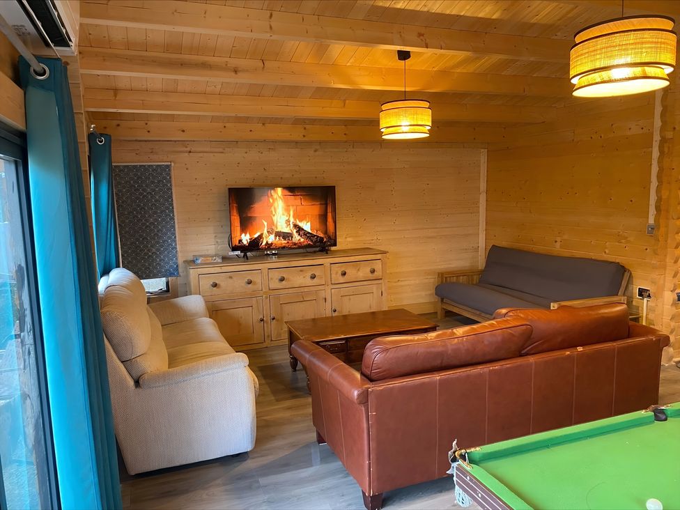 A living room with sofas and pool table at Cotswold Nights in Evesham