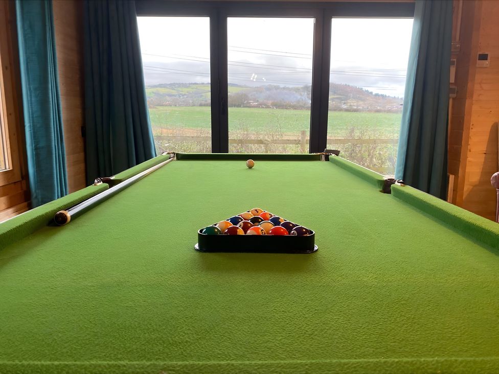 A pool table with balls set up near a window at Cotswold Nights in Evesham