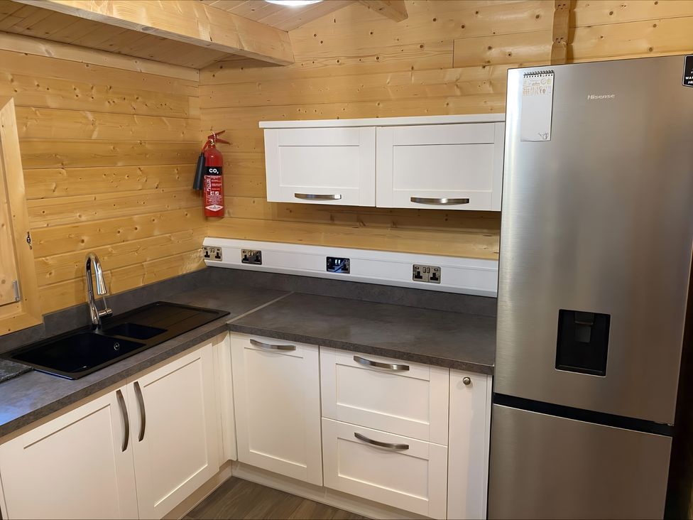 A kitchen with a refrigerator and countertop at Cotswold Nights in Evesham