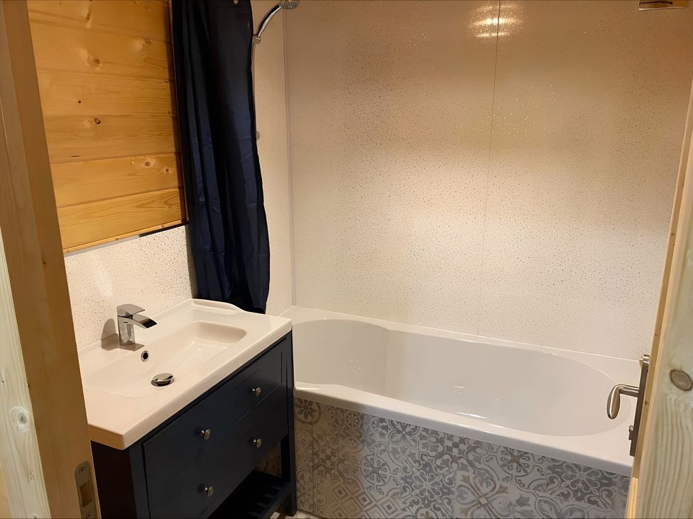 A bathroom with a bathtub and sink at Cotswold Nights Evesham