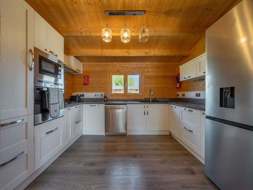 A kitchen with appliances and wooden decor at Cotswold Nights Ashton Under Hill