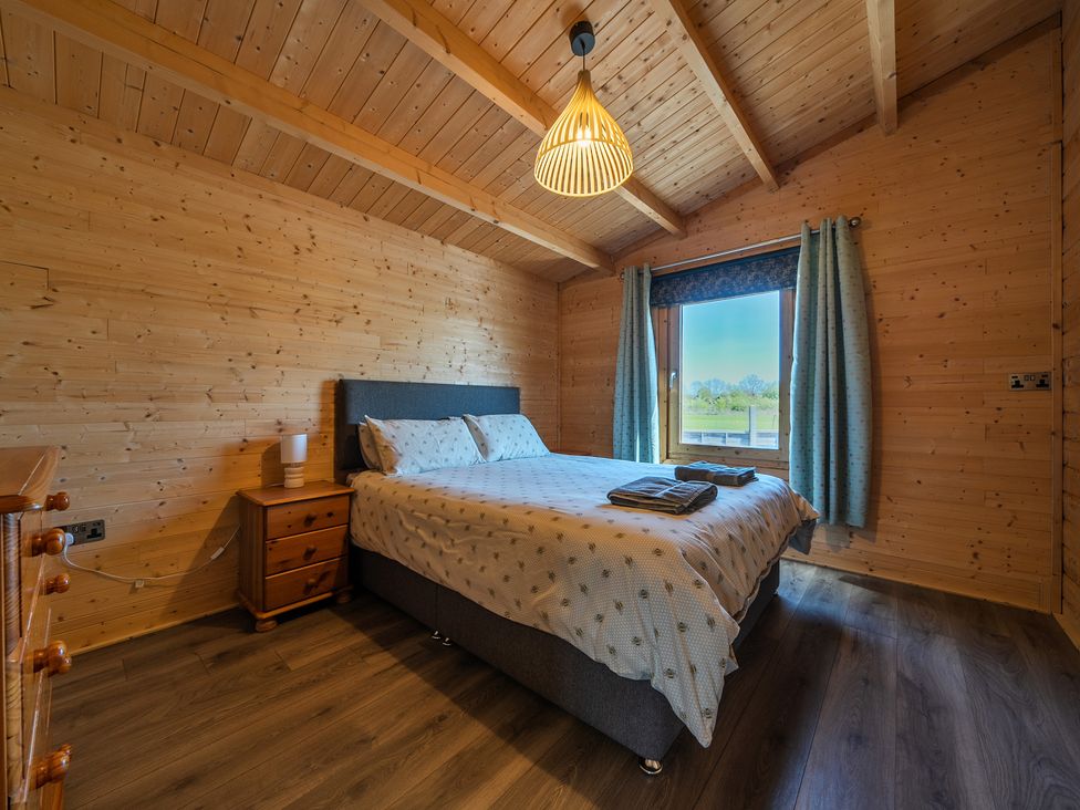 A bedroom with a bed and nightstand at Cotswold Nights Ashton Under Hill
