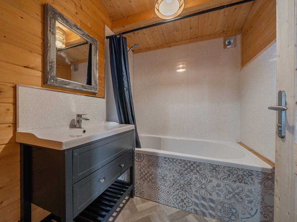A bathroom with a bathtub and sink at Cotswold Nights Ashton Under Hill
