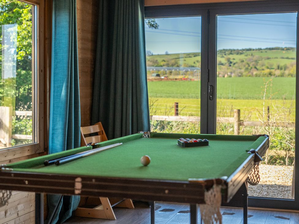 A pool table with a cue stick and balls at Cotswold Nights Ashton Under Hill