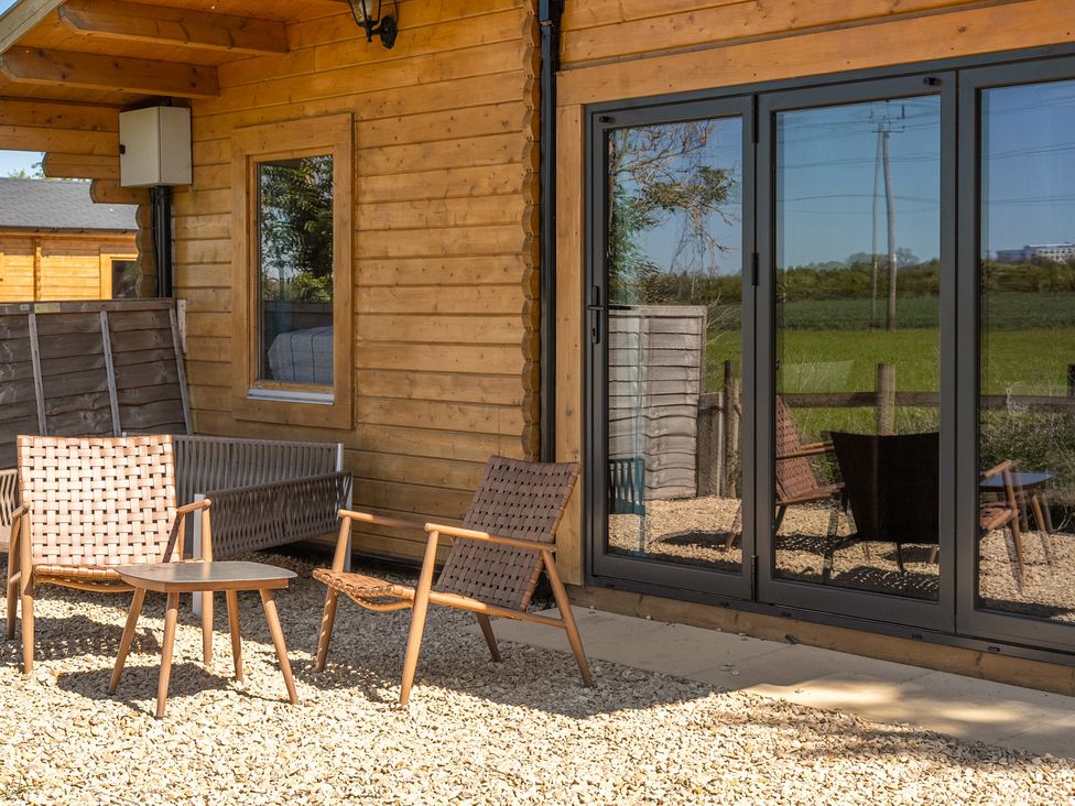 An outdoor seating area with chairs and table at Cotswold Nights Ashton Under Hill