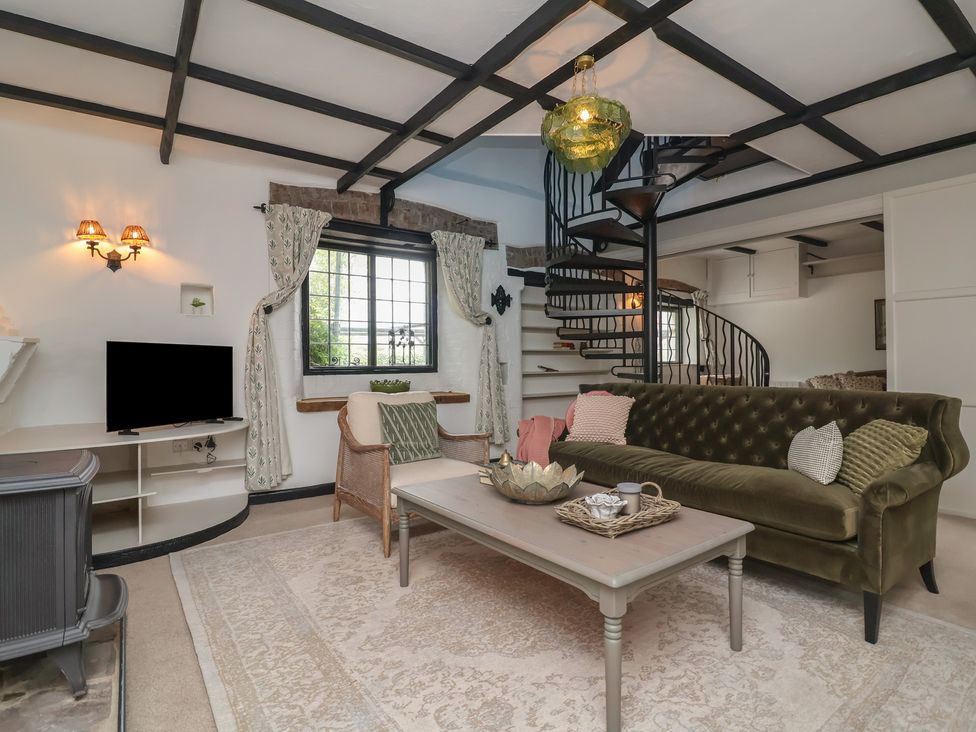 A living room with a sofa, coffee table, and television at The Olde Forge in Minehead
