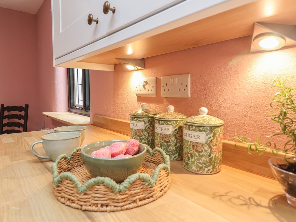 A kitchen countertop with jars and cups at The Olde Forge in Minehead