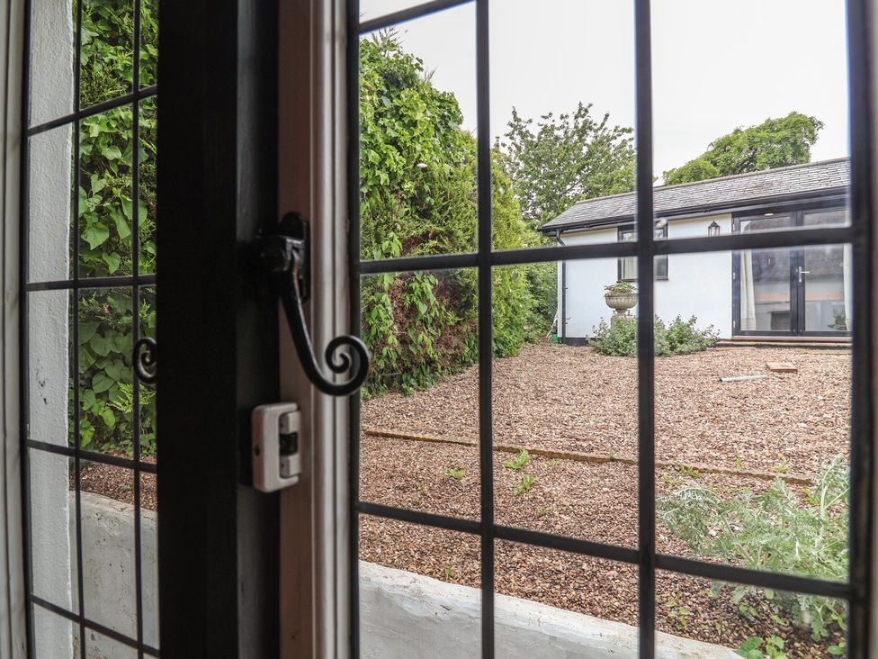 A view of a garden with gravel and plants from a window at The Olde Forge in Minehead
