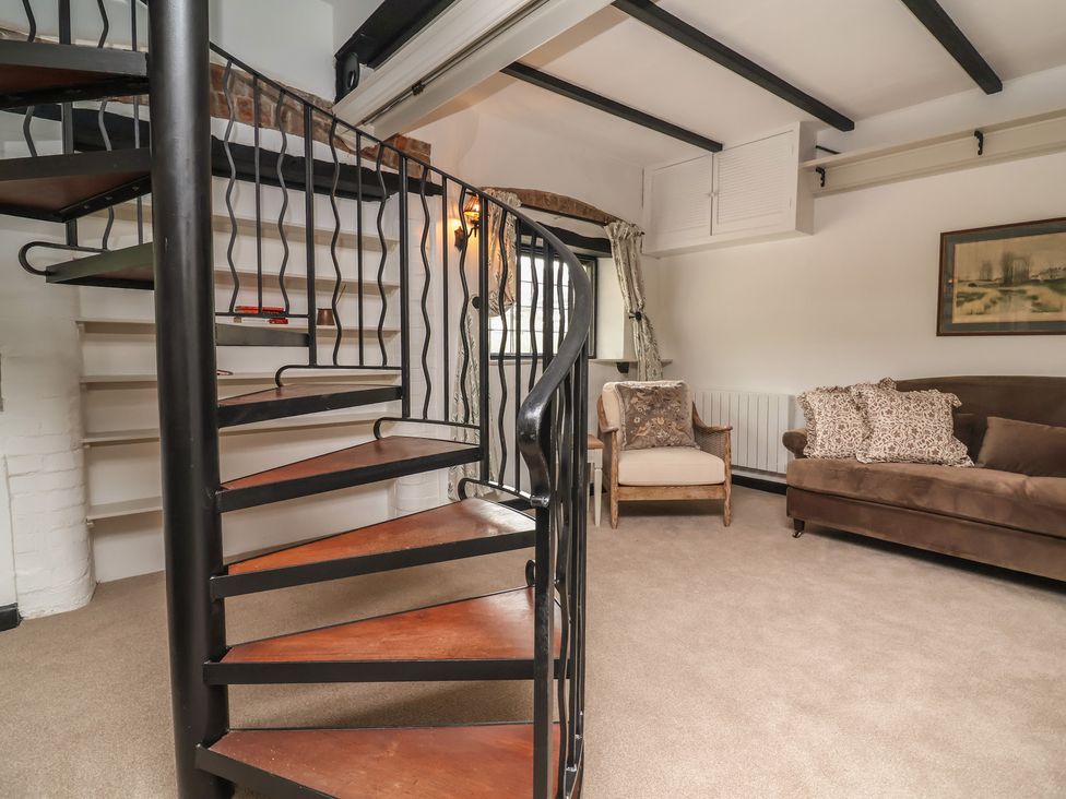 A living room with a spiral staircase and seating area at The Olde Forge in Minehead