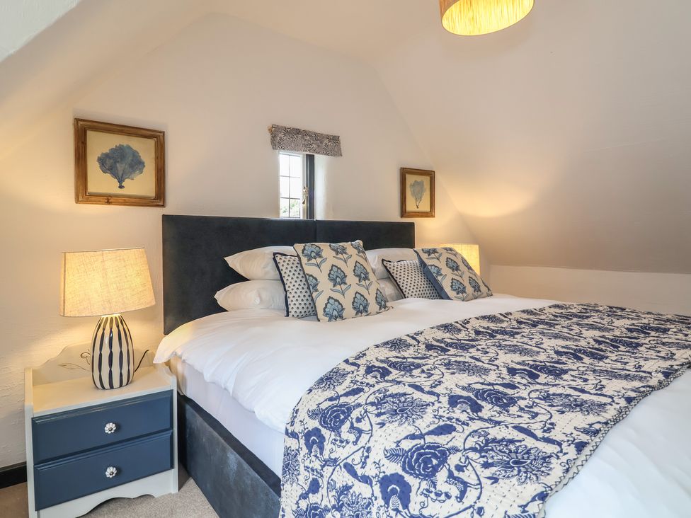 A bedroom with a bed and nightstand at The Olde Forge in Minehead