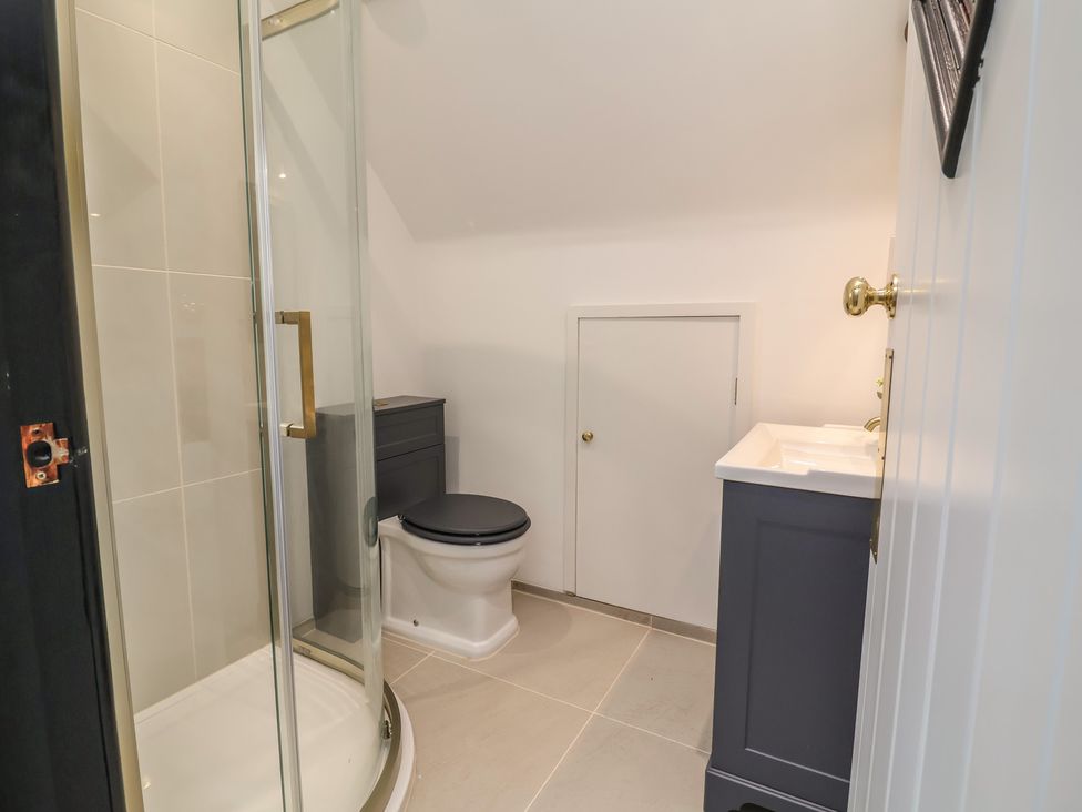 A bathroom with a shower, toilet, and sink at The Olde Forge in Minehead