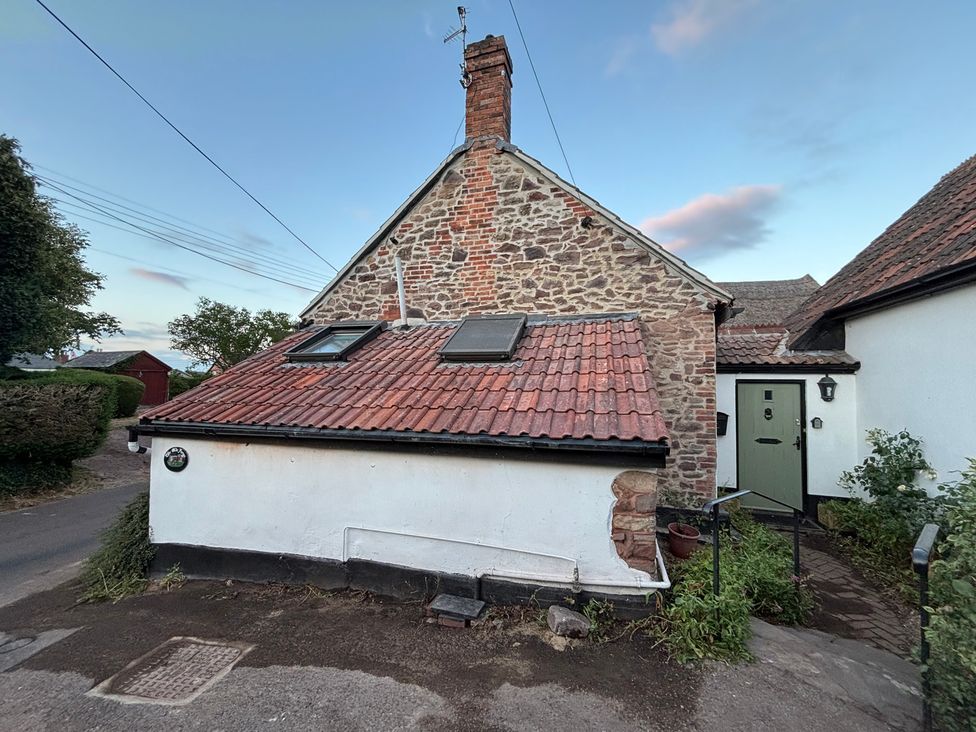 An exterior view of a cottage with a garden at The Olde Forge in Carhampton near Minehead