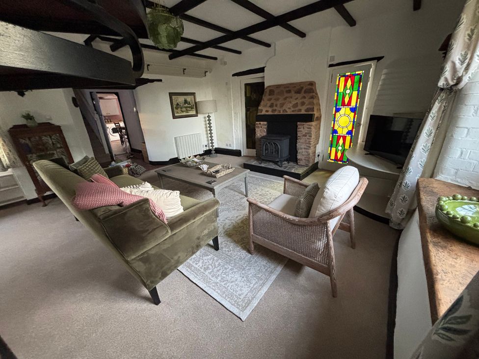 A living room with a sofa and armchairs around a coffee table at The Olde Forge in Carhampton near Minehead