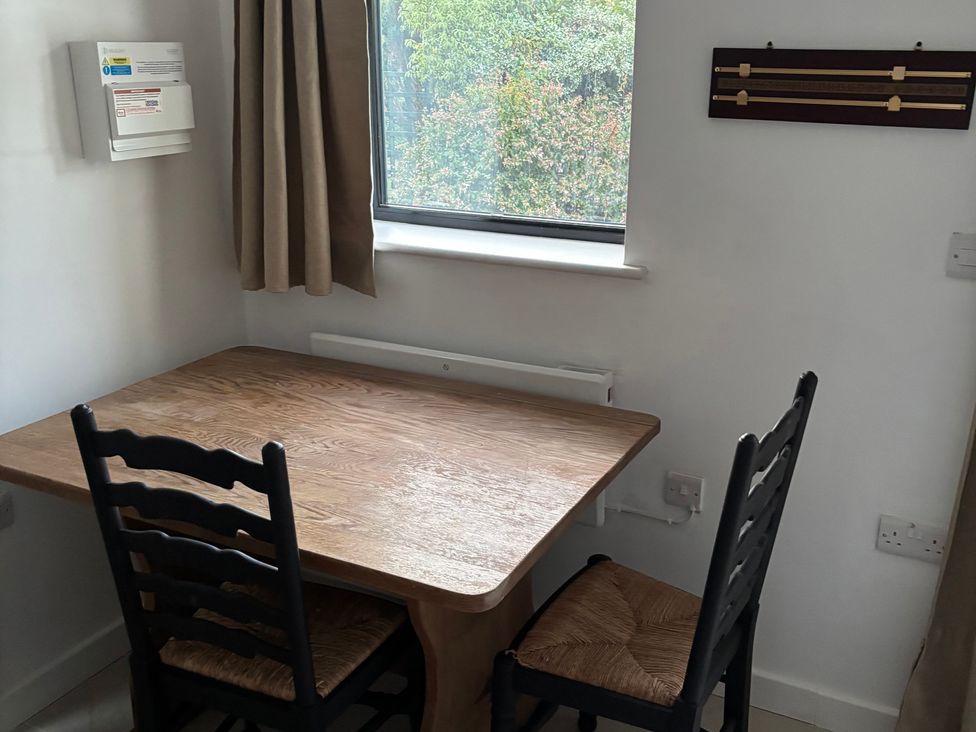A dining room with a table and two chairs at The Olde Forge in Carhampton near Minehead