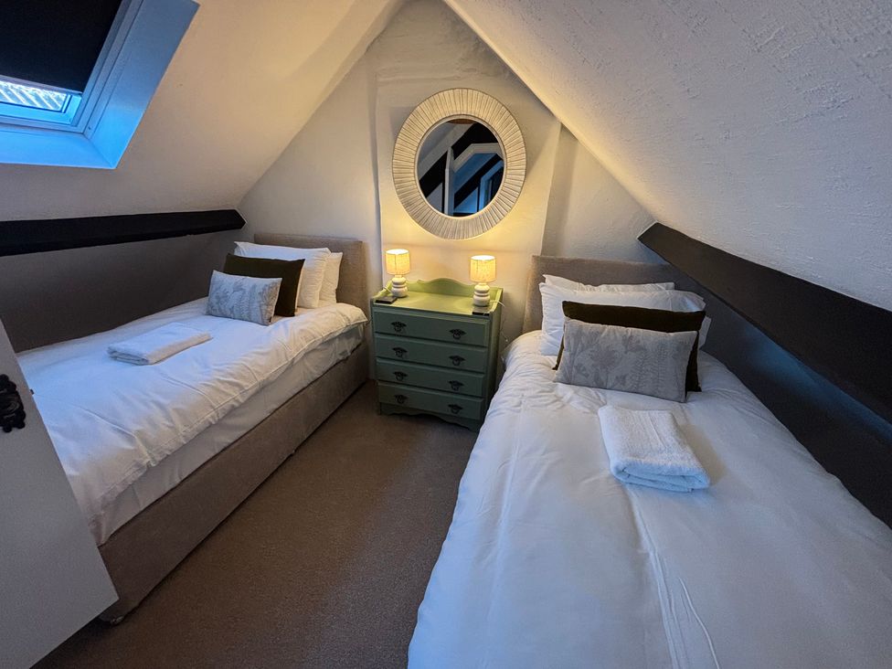 A bedroom with two beds and a mirror at The Olde Forge in Carhampton near Minehead