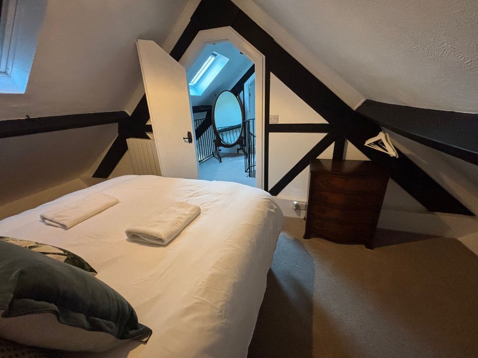 A bedroom with a bed and towels at The Olde Forge in Carhampton near Minehead