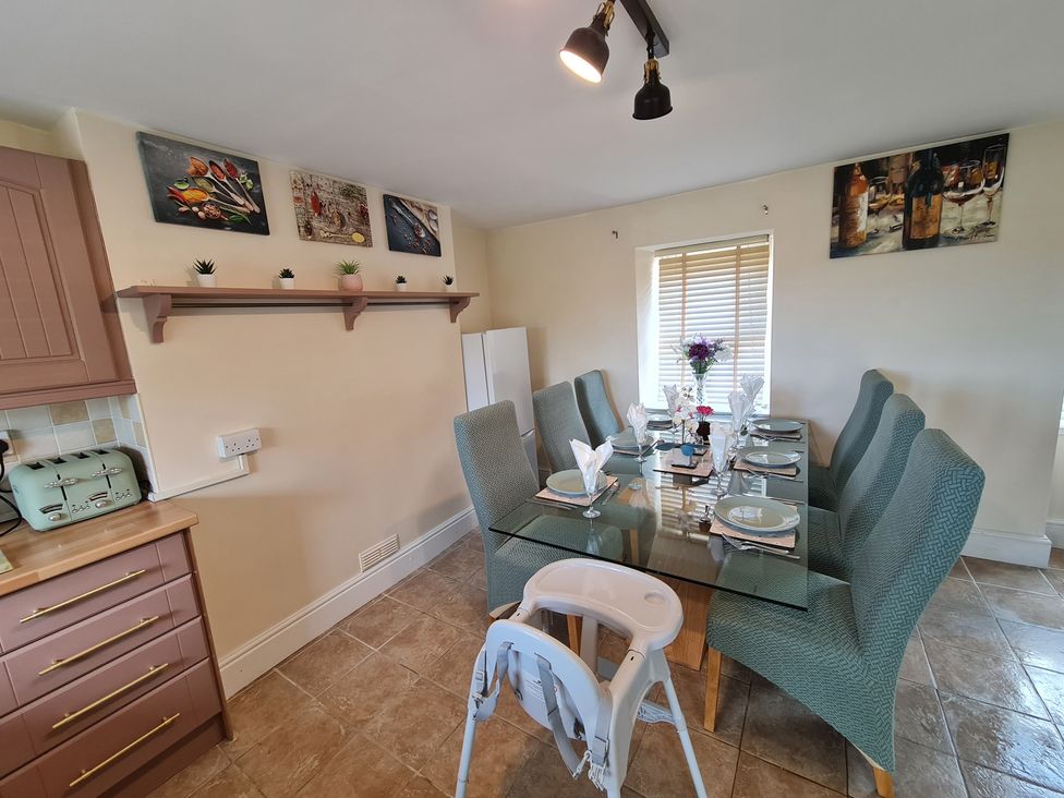 A dining room with a glass table and chairs at Sea view cottage in Penmaenmawr