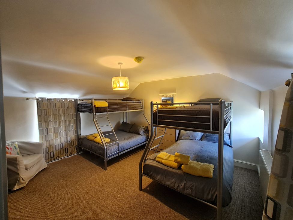 A bedroom with bunk beds and a couch at Sea view cottage in Penmaenmawr