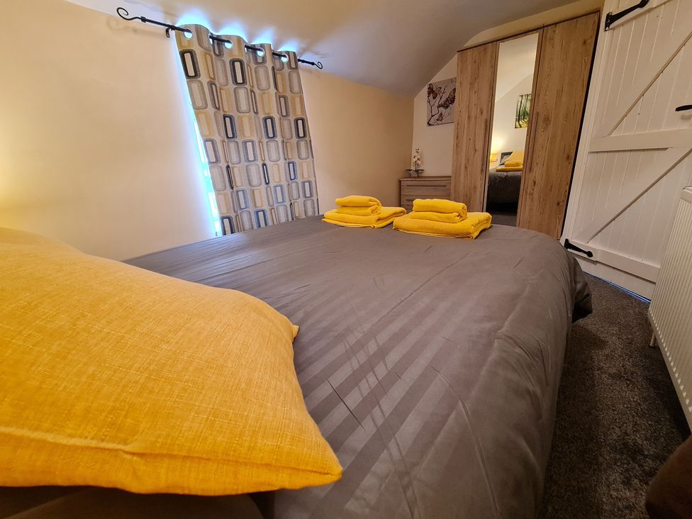 A bedroom with a bed and towels at Sea view cottage in Penmaenmawr