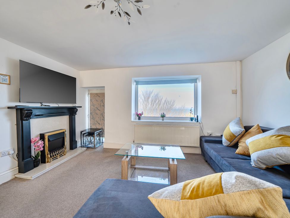 A living room with a sofa and television at Sea view cottage Penmaenmawr