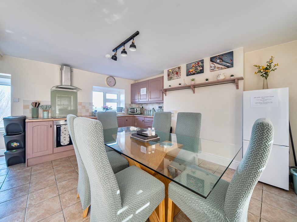 A kitchen with a dining table and chairs at Sea view cottage Penmaenmawr