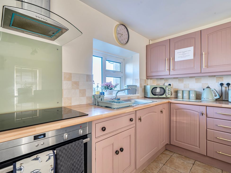 A kitchen with sink and appliances at Sea view cottage in Penmaenmawr