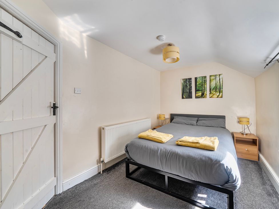 A bedroom with a bed and wall art at Sea view cottage Penmaenmawr