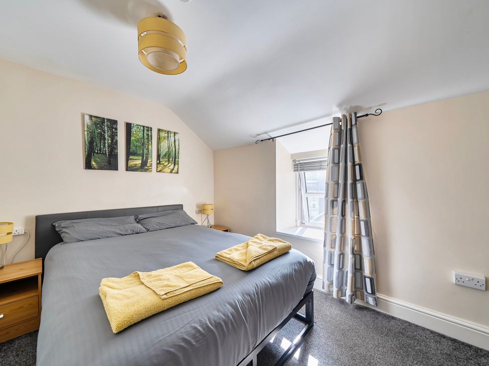 A bedroom with a bed and wall art at Sea view cottage in Penmaenmawr
