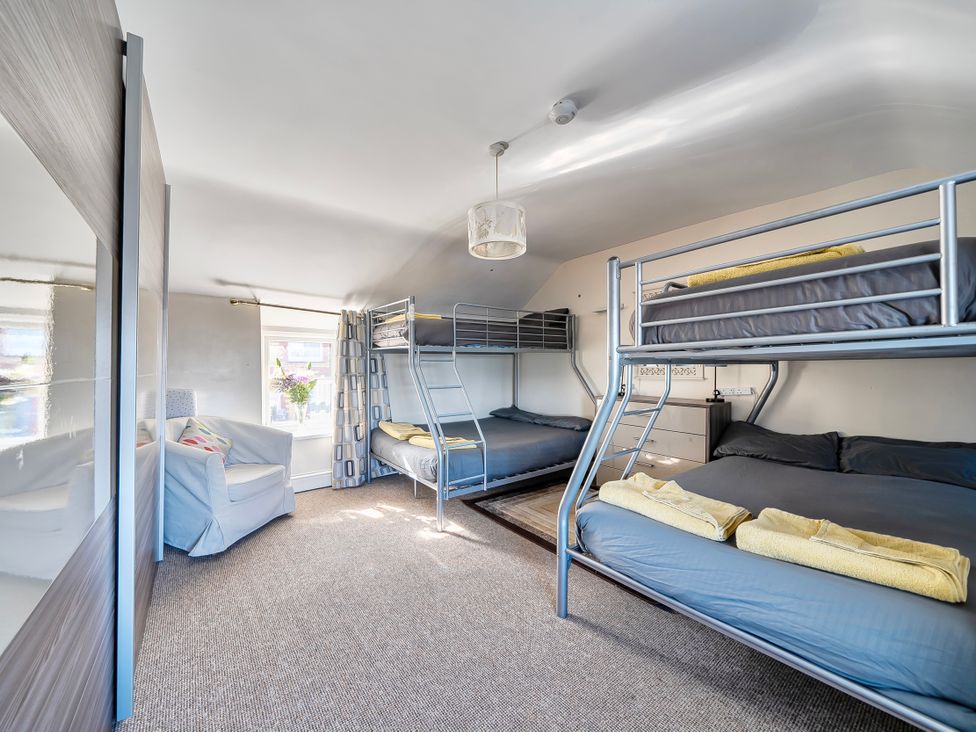A bedroom with bunk beds and a double bed at Sea view cottage in Penmaenmawr