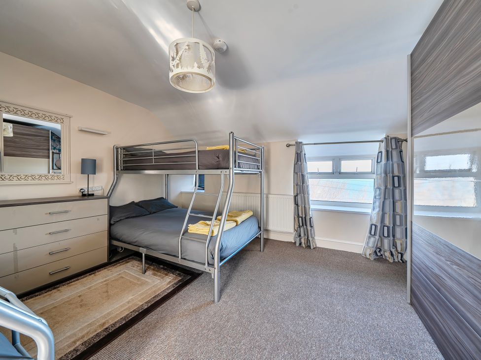 A bedroom with a bunk bed and dresser at Sea view cottage Penmaenmawr
