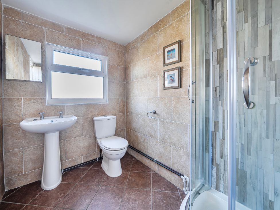A bathroom with a sink, toilet, and shower at Sea view cottage in Penmaenmawr