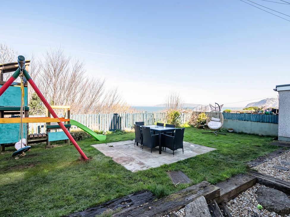 A garden with swing set and table in Sea view cottage Penmaenmawr