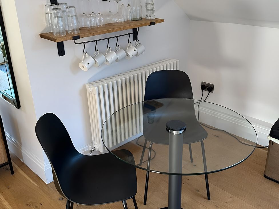 A dining room with a glass table and black chairs at Hope Valley - Studio in Hope Valley