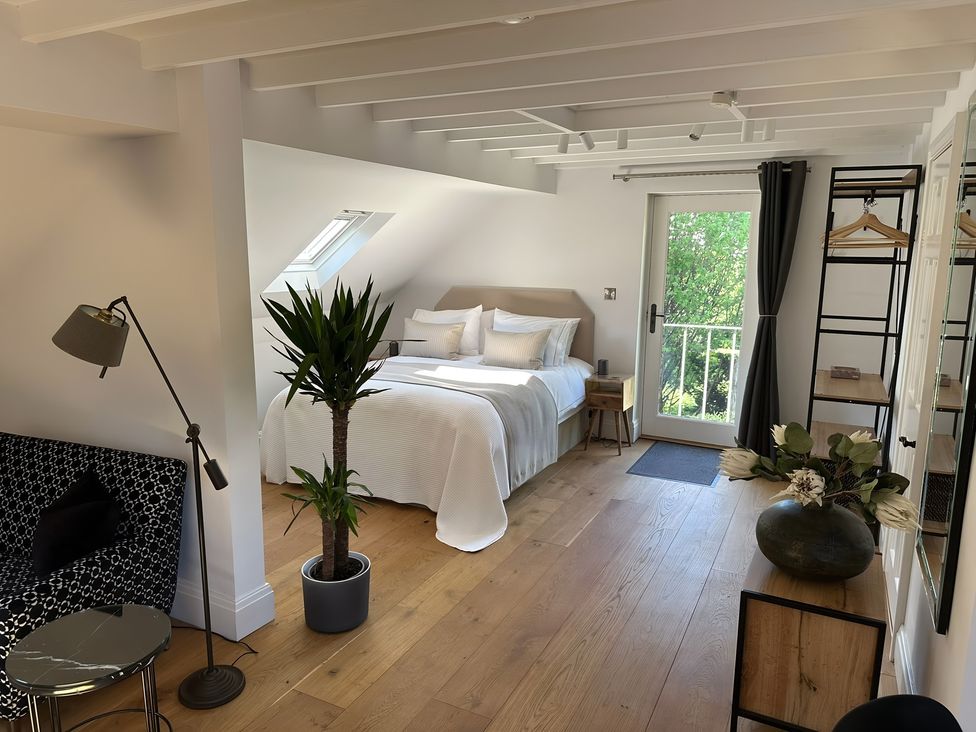 A bedroom with a bed and a balcony door at Hope Valley - Studio in Hope Valley