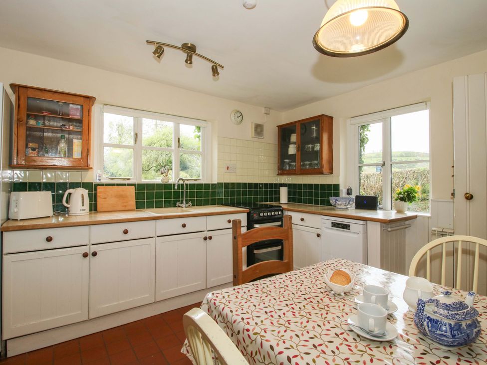 A kitchen with appliances and a dining table at Cardington 25