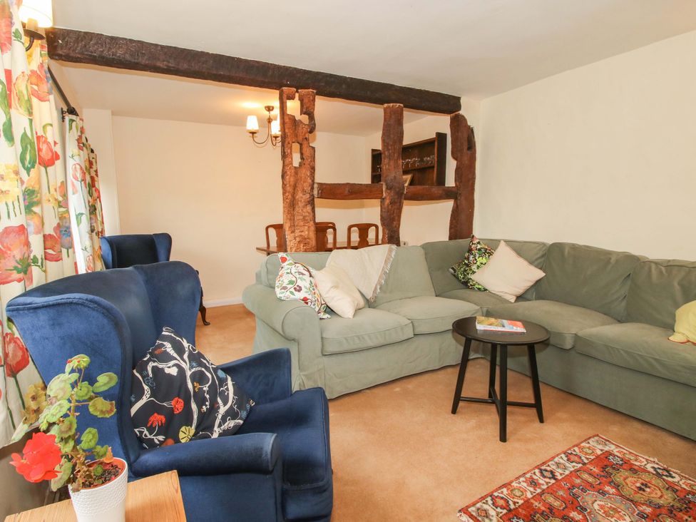 A living room with a sofa, armchair, and dining table at Cardington 25