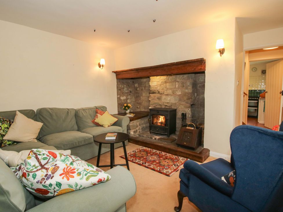 A living room with a fireplace and sofa at Cardington 25