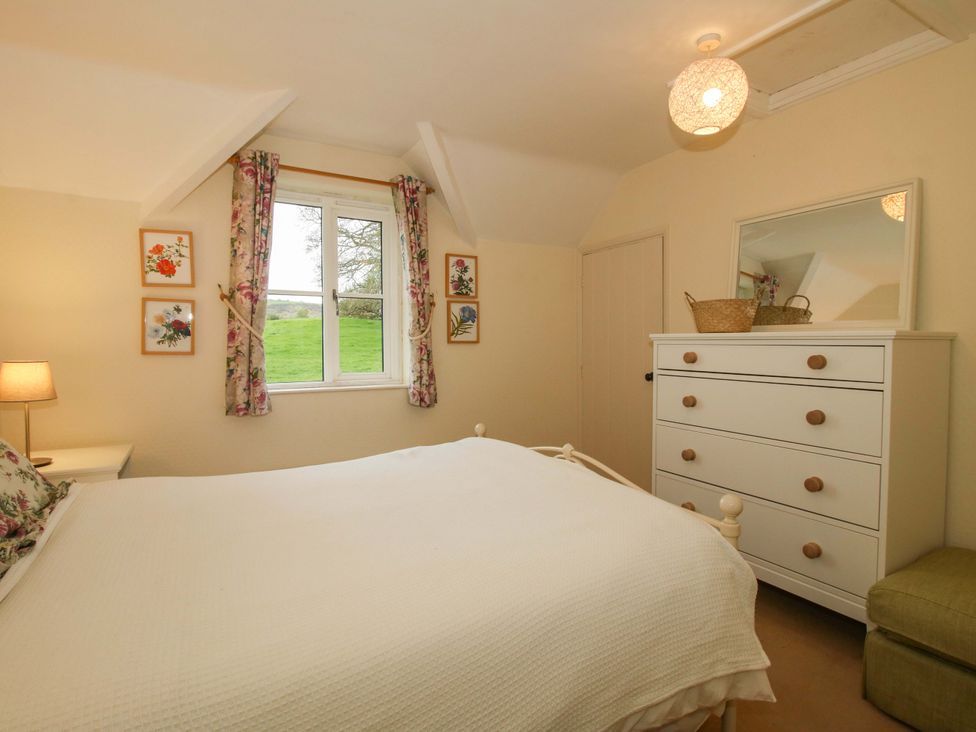 A bedroom with a bed, dresser, and window at Cardington 25