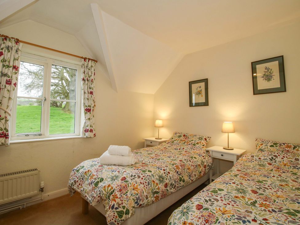 A bedroom with two beds and a window at Cardington 25
