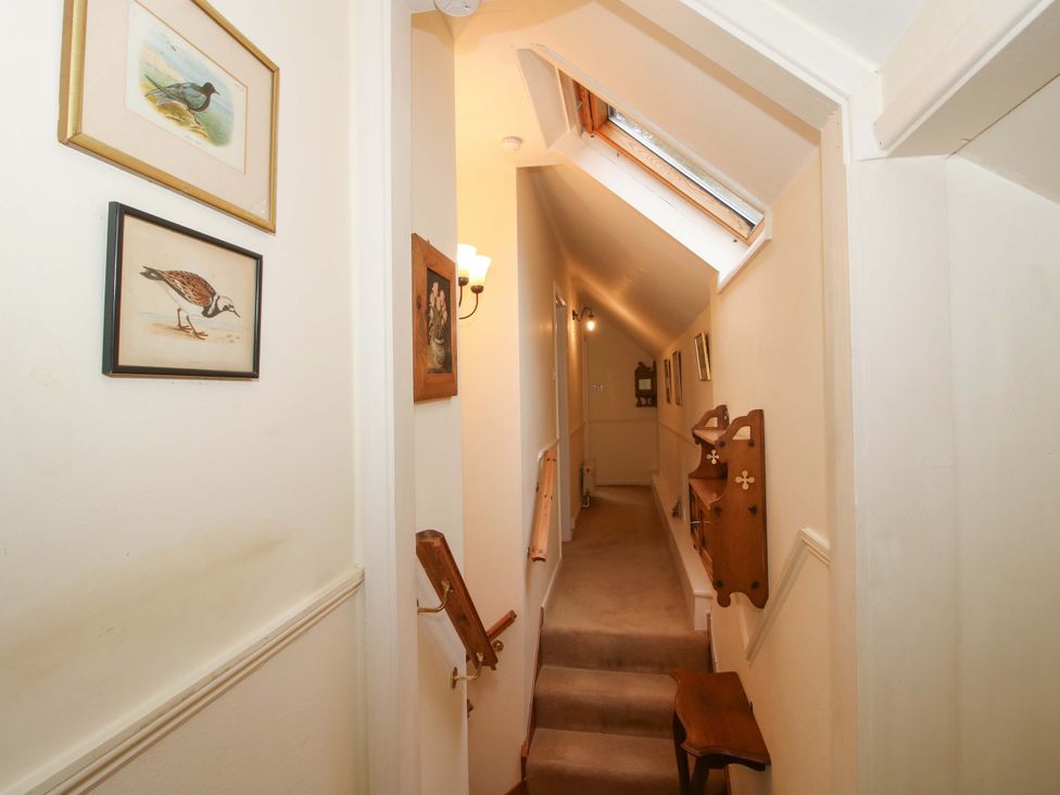A hallway with stairs and artwork on the walls at Cardington 25