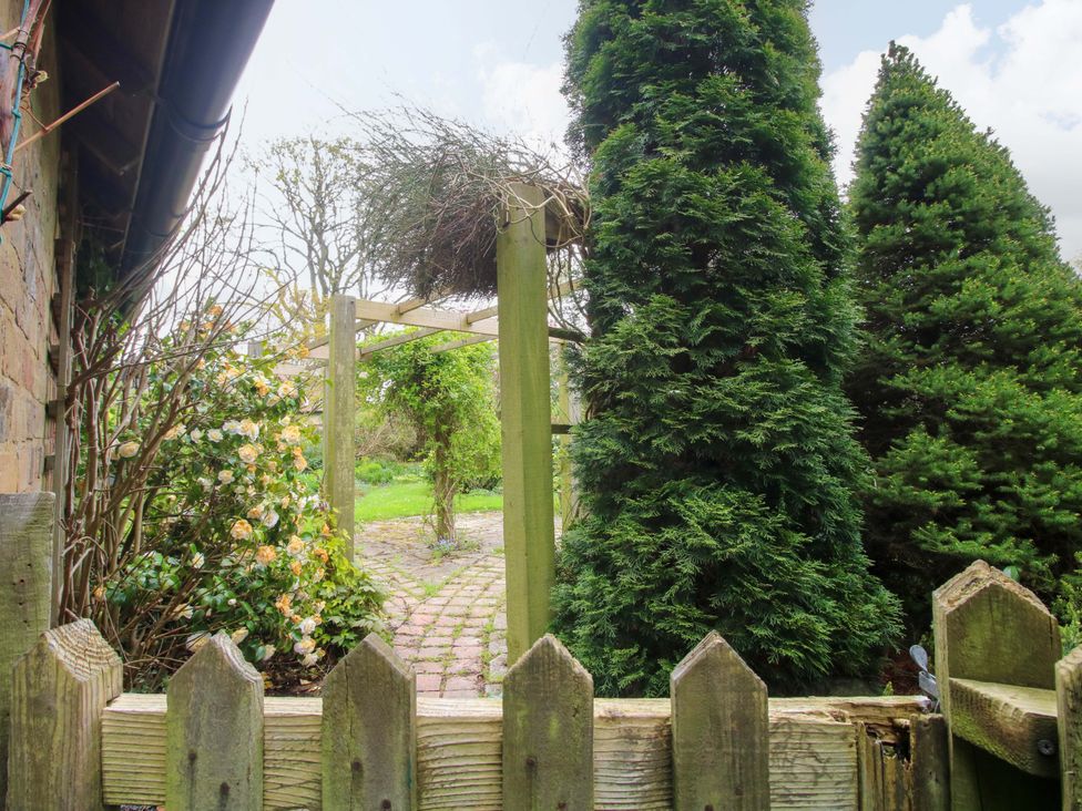 A garden with a gate and pathway at Cardington 25