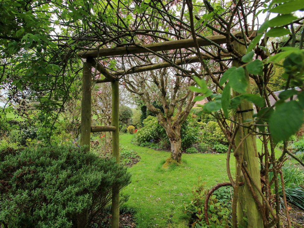 A garden with a pathway and a wooden archway at Cardington 25 