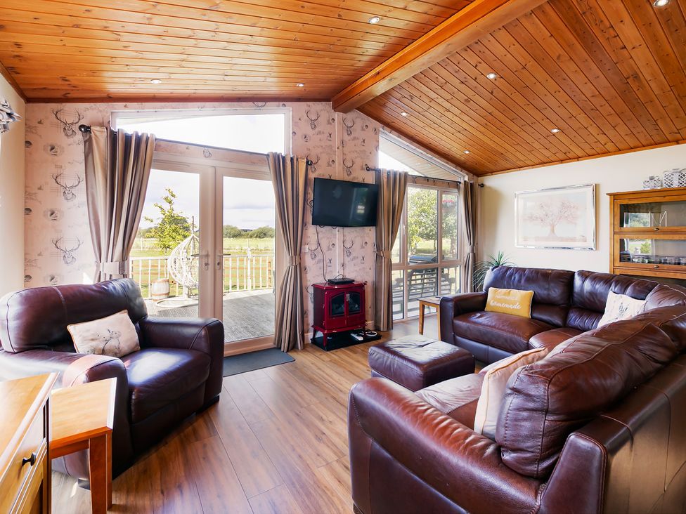 A living room with a television and seating at Hedgehog Lodge in York