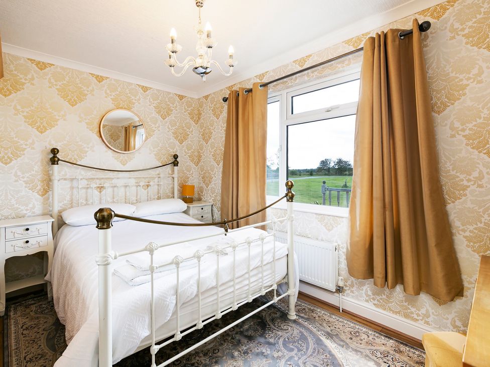 A bedroom with a bed and nightstand at Hedgehog Lodge in York