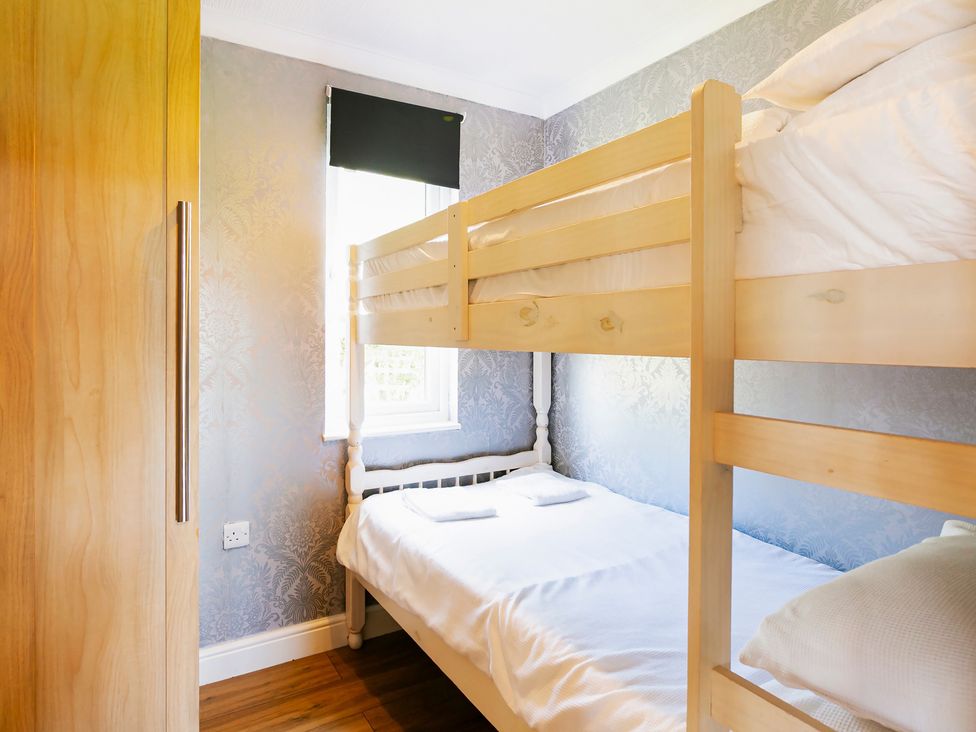 A bedroom with a bunk bed and a double bed at Hedgehog Lodge in York