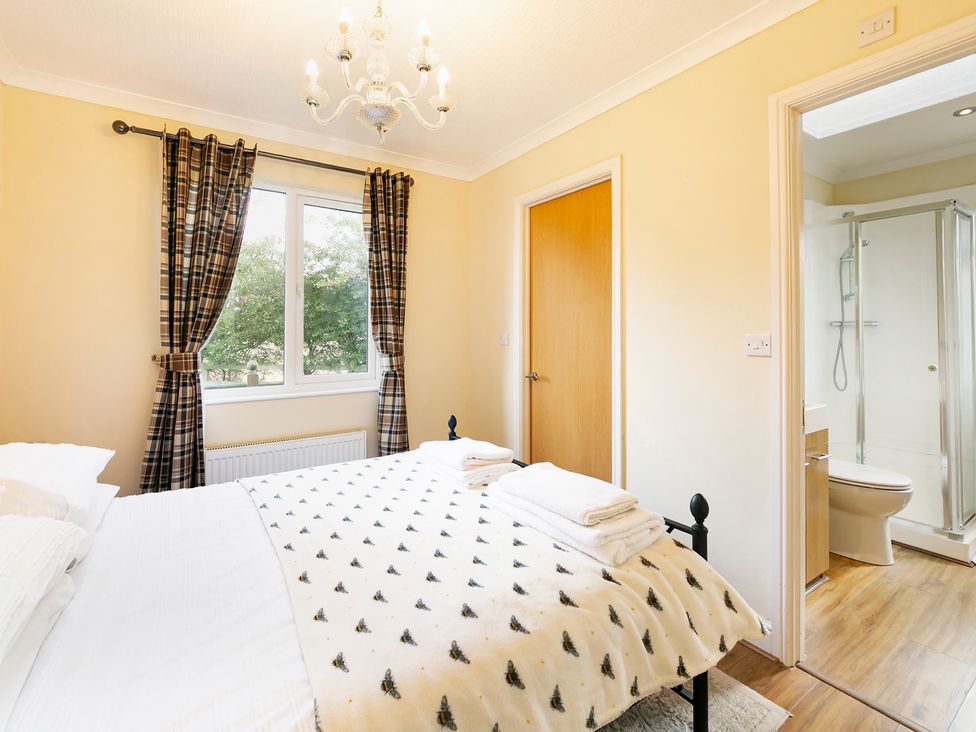 A bedroom with a bed and adjoining bathroom at Hedgehog Lodge in York