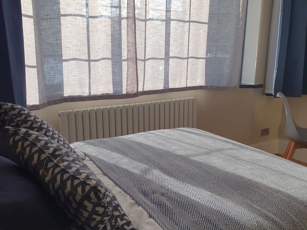 A bedroom with a bed and window with curtains at Kinamara Ensuite Room