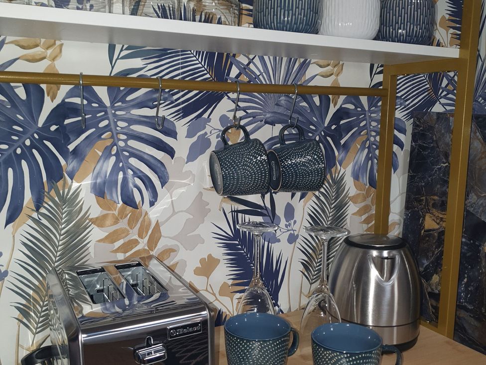 A kitchen area with kitchen appliances and cups at Kinamara Ensuite Room