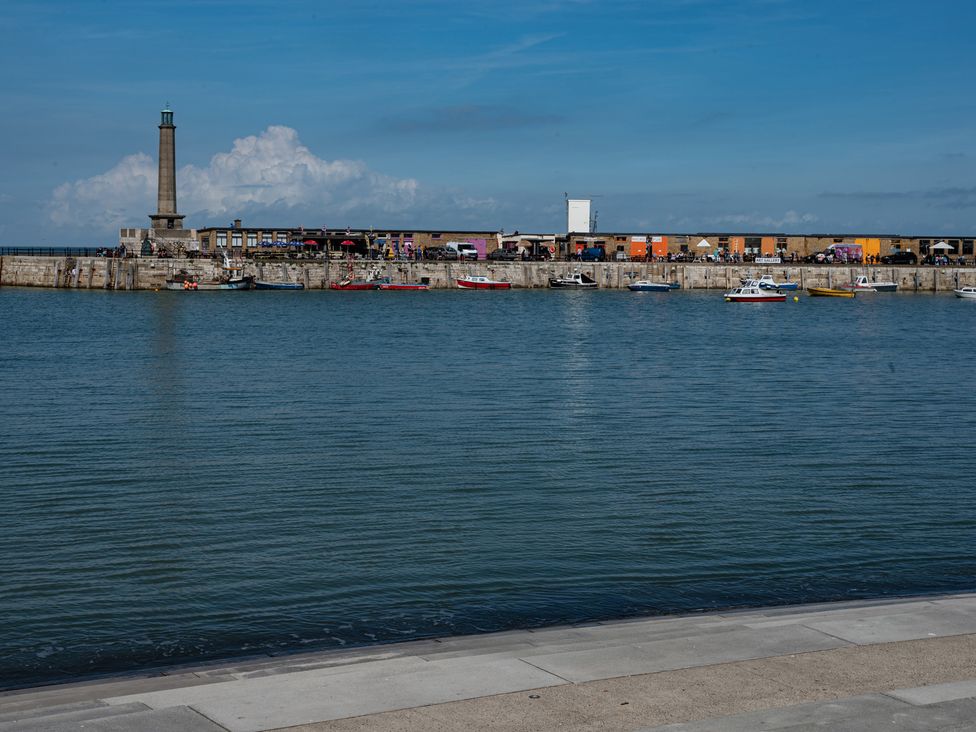 A view of a pier with a lighthouse and boats at a harbor at Kinamara Ensuite Room